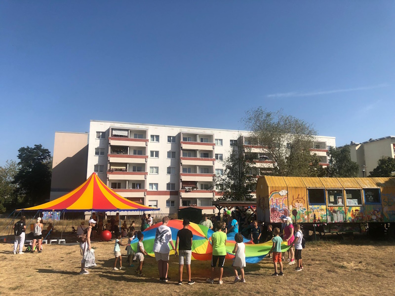 Bauwagen mit Manschen und buntem Tuch davor