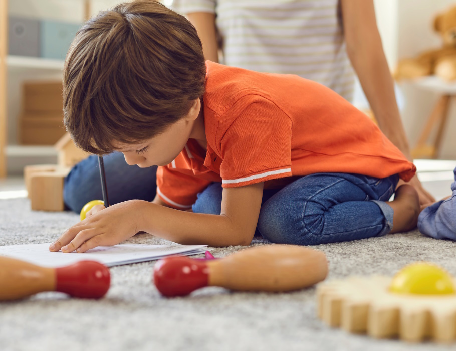 Ein Kind auf dem Boden, das malt