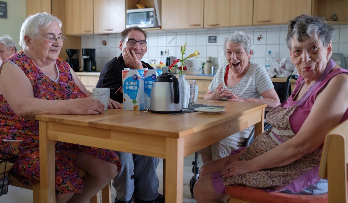 Gemeinsames Wohnen, 4 Personen an einem Küchentisch